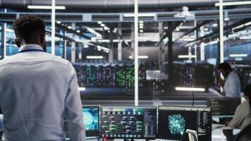 Server hub programmer using AI machine learning node tree software to optimize system health. Data center IT expert analyzing equipment issues using artificial intelligence visualization, camera A video
