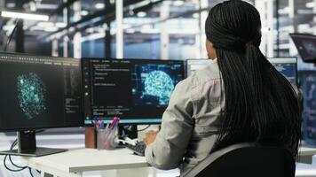 Server farm IT specialist using PC to apply artificial intelligence technology minimizing system downtime. Engineer using computer to develop and deploy AI solutions optimizing equipment, camera B video