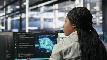 Data center worker applies deep learning node tree programming to analyze datasets for operational insights. Server hub admin uses visual programming to identify patterns in facility data, camera B video