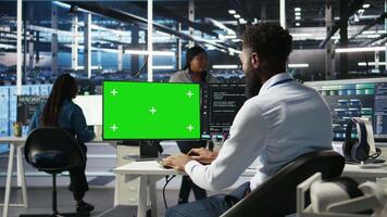 Data center admin using AI node tree software on isolated screen PC to minimize system downtime. Server hub worker uses artificial intelligence visual programming tool on chroma key computer, camera A video
