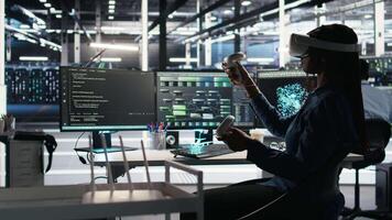 Server farm admin using VR equipment and node tree systems to categorize unstructured data. Data center IT specialist uses virtual reality headset and visual programming software, camera A video