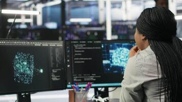Data center software developer using artificial intelligence deep learning models to configure hardware. IT professional works on AI programming language in server farm, optimizing system, camera B video