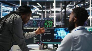 Data center supervisor overseeing work done by engineer using deep learning algorithms to analyze datasets. Server room team leader worker supervising using AI tech to recognize data patterns video