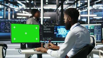 Data center admin using AI node tree software on isolated screen PC to minimize system downtime. Server hub worker uses artificial intelligence visual programming tool on chroma key computer, camera B video