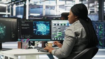 Data center admin does neural networks node tree programming, optimizing resource allocation. Server room IT professional uses predictive deep learning AI visualization systems, camera B video