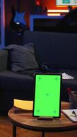 Vertical African american man browses mobile phone next to mockup copy space while he relaxes on a bean bag, feeling satisfied and casual. Freelancer in the living room feels happy with remote job. Camera A. video