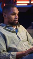 Vertical Black man joining online lesson to work on new skills from home space, attend web conference call and watching lecture from loft. Person participates at a virtual training class. Camera B. video