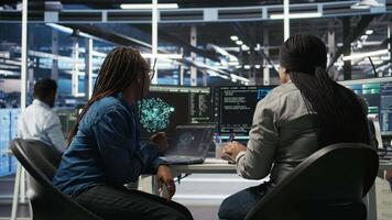 Data center coworkers doing brainstorming, using artificial intelligence machine learning models to configure equipment. IT experts cooperating in server farm, working on optimizing systems, camera A video