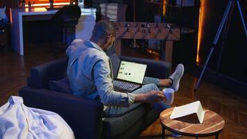 schwarz männlich Händler Überwachung Lager Markt echt Zeit Änderungen auf Laptop, investieren Mittel mit das Tor zu Boost Verdienste. konzentriert jung Kerl studieren wirtschaftlich Werte zum global Förderung. Kamera a. video
