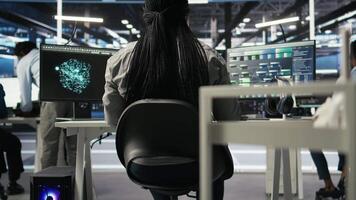 Data center programmer using artificial intelligence deep learning models to configure infrastructure. IT staff member works on AI programming language in server room, optimizing system, camera A video