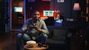 POV young black adult enjoying free time playing shooter games on smart tv, plugging console in the living room and spending game session at night. Man engaging in fun activity. Camera A. video