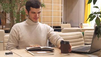 Young man enjoys coffee while working in a modern hub video