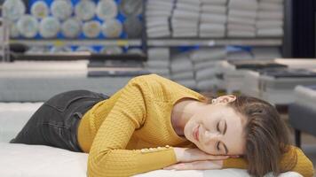 Radiant woman joyfully posing on a plush orthopedic mattress in a stylish store video