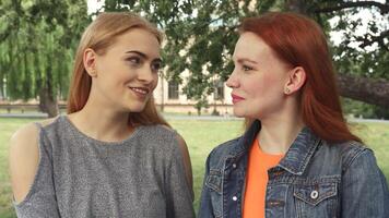 Two girls joyfully posing for a camera, creating a heart shape with their hands video