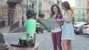 Adventurous female friends exploring a city with a map video