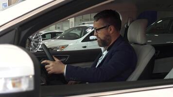 Sales manager approaches the car with a customer inside, showcasing features video