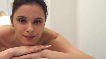 Brunette girl enjoys a serene moment on the massage table video