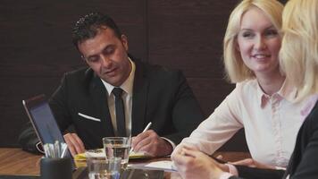 Confident businessman signs documents while smiling at the camera video