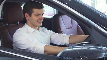 Young man joyfully grips the steering wheel of a sleek new car video