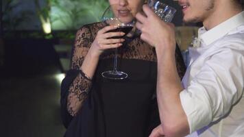 Young couple toasting with drinks at a stylish bar during a romantic date video