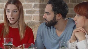 Dynamic gathering of young friends enjoying lively conversations over beers at the pub video