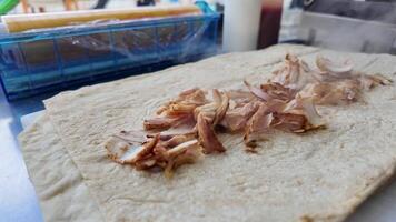 Preparing a traditional wrap with sliced meat at a local market video