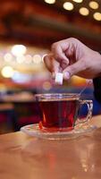 Enjoying a warm cup of tea and adding sugar in a cozy cafe setting video