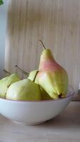 Fresh pears in a bowl on wooden table with cloth napkin video