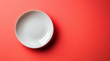 Simple White Ceramic Plate on a Solid Coral Background Ideal for Table Setting and Culinary Photography photo
