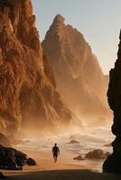 A solitary person with a backpack walks barefoot along a sandy beach framed by towering cliffs and a crashing ocean. photo