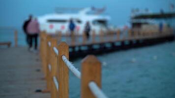 Wooden pier with people and a white yacht video