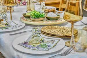 A close-up view of a traditional Passover seder plate with symbolic foods including eggs, herbs, shank bone, and charoset photo