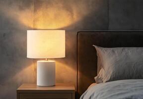 A lamp is lit up on a bedside table photo