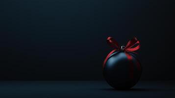 A black ball with a red ribbon on it sits on a dark background photo