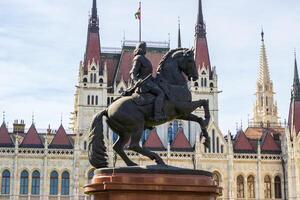ecuestre estatua en frente de húngaro parlamento edificio en budapest, fotografiado en abril 14, 2024. histórico Monumento y arquitectónico antecedentes foto