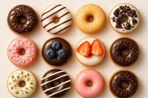 Assorted donuts with chocolate, fruit, glaze, and sprinkles toppings arranged in grid on light background, sweet dessert food concept photo