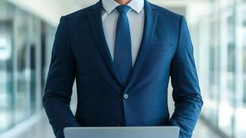 Businessman holding a laptop in a modern office setting. photo