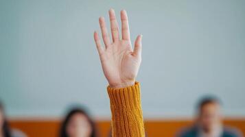 A hand raised in a classroom setting, signaling a question or participation. photo