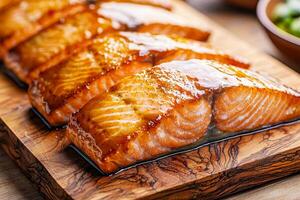 Freshly cooked salmon fillets on a wooden cutting board. photo