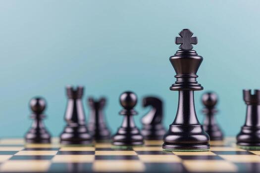 Black chess pieces on a board with a light blue background. photo
