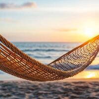 Hammock at sunset by the beach with ocean waves in the background. photo