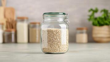 Glass jar filled with chia seeds on a kitchen countertop. photo