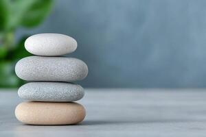Stacked smooth stones on a soft surface with a green background. photo