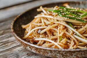 Delicious noodle dish with sesame and green onions in a rustic bowl. photo
