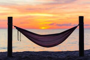 Serene hammock by the beach at sunset, inviting relaxation and tranquility. photo