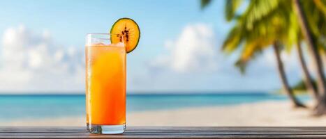 Refreshing orange drink by the beach with palm trees in the background. photo
