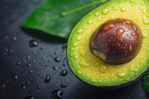 Fresh avocado with water droplets on a dark surface. photo