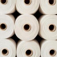 Rolled fabric spools stacked in a neat arrangement. photo
