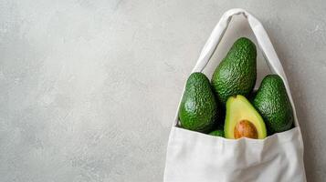 Fresh avocados in a reusable bag on a textured background. photo