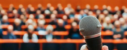 Microphone in focus with blurred audience in the background. photo
